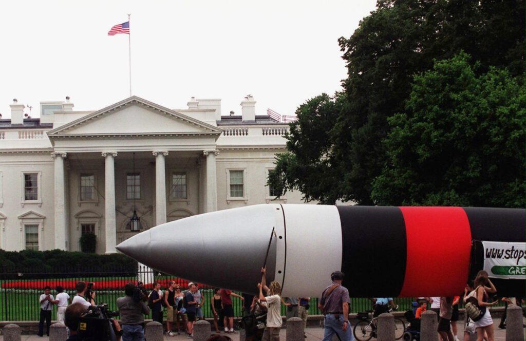 Demonstrators carry a dummy ICBM past the White House